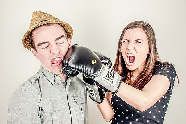 Man getting punched in the jaw by woman wearing boxing glove